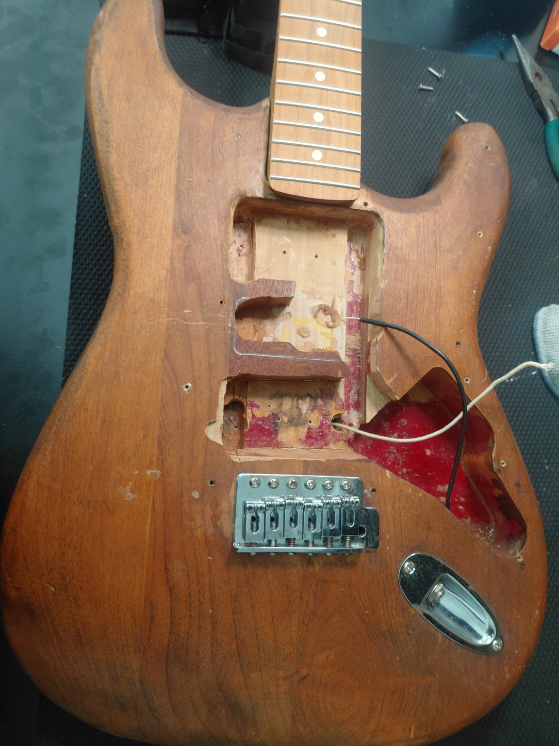 Damaged guitar body and pickup cavities before repair at Deloach’s Music